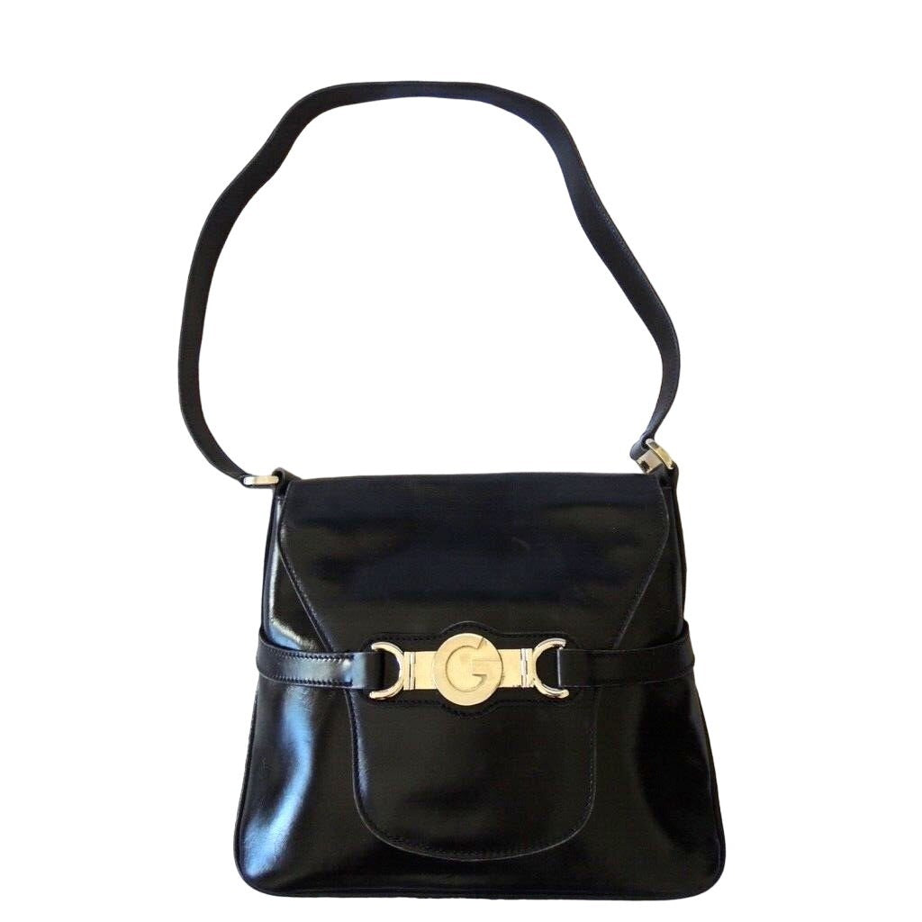 1970s GCCI saddle bag in black leather with muted gold hardware, an expandable bottom, wide shoulder strap, and burgundy leather lining