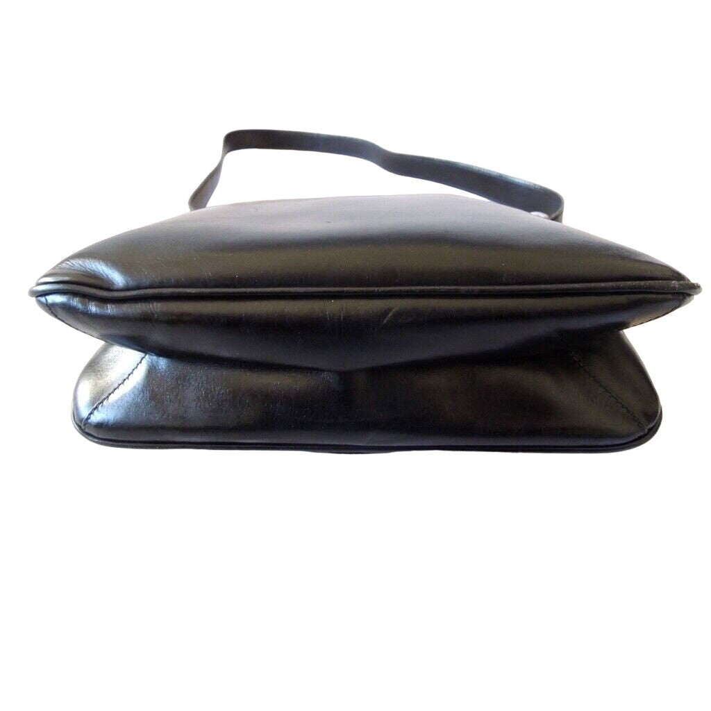 1970s GCCI saddle bag in black leather with muted gold hardware, an expandable bottom, wide shoulder strap, and burgundy leather lining